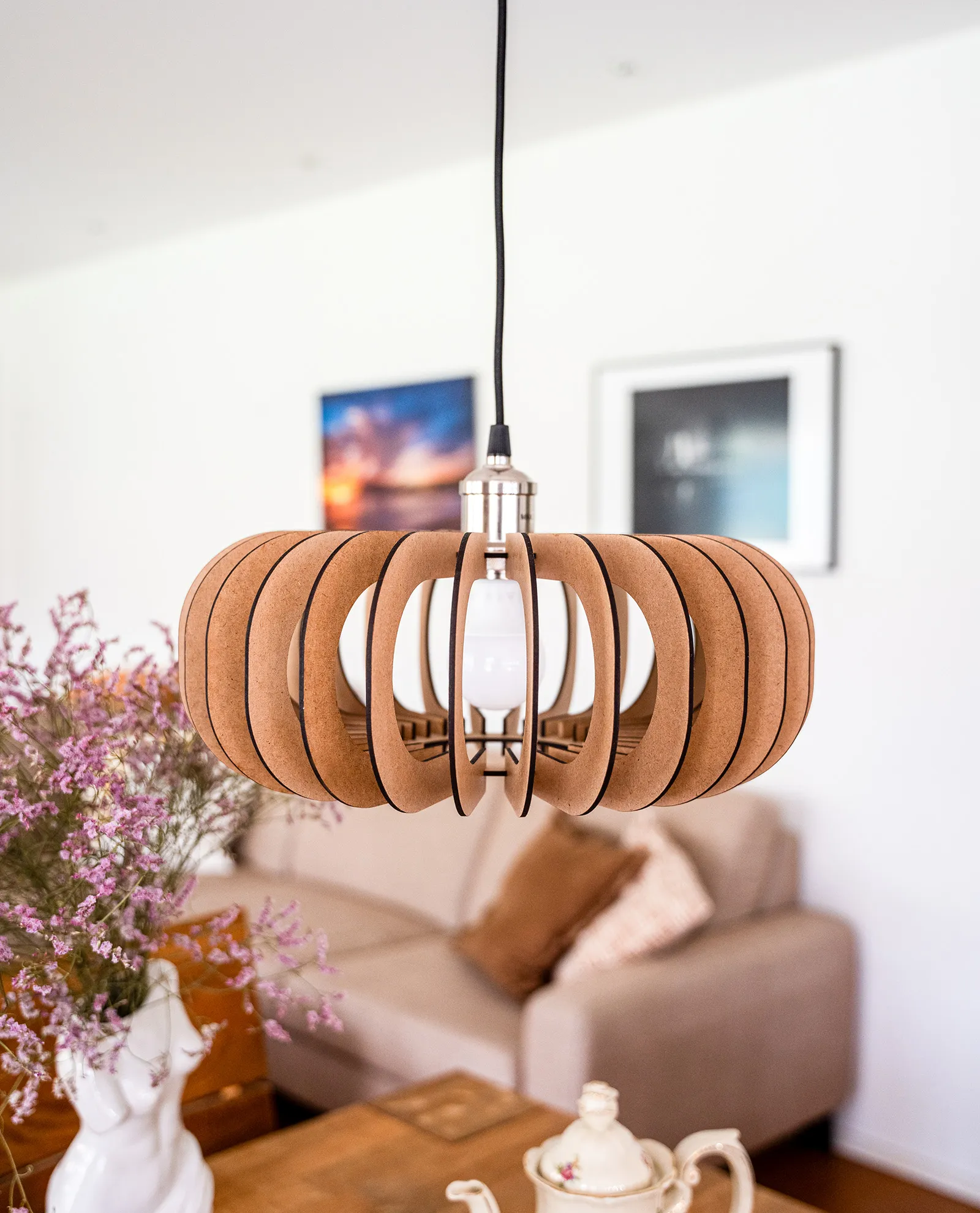 Moderne Pendelleuchte aus umweltfreundlichem Holz, die ein helles, skandinavisches Wohnzimmer stilvoll beleuchtet