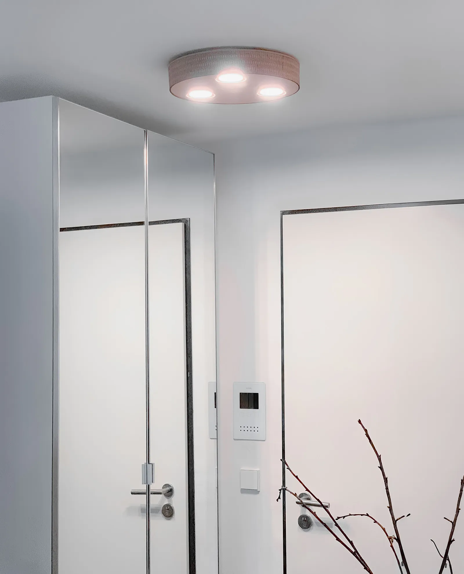 Elegante Deckenlampe aus Holz mit rundem Design, montiert in einem weißen, lichtdurchfluteten Flur für ein warmes und stilvolles Ambiente